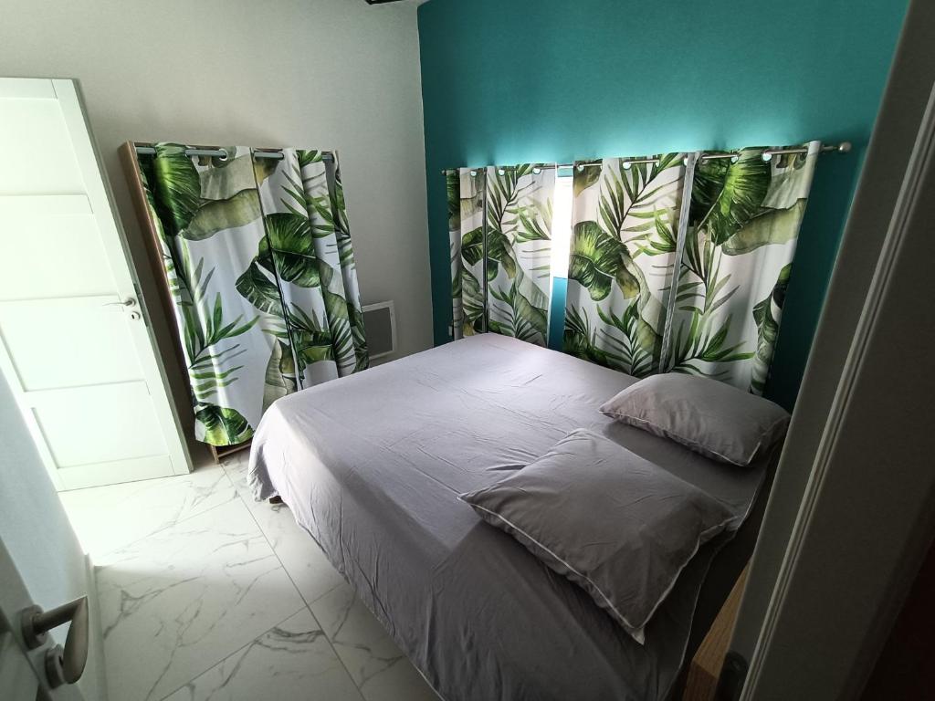 ein Schlafzimmer mit einem Bett mit einer grünen Wand in der Unterkunft Villa du soleil in Les-Pennes-Mirabeau