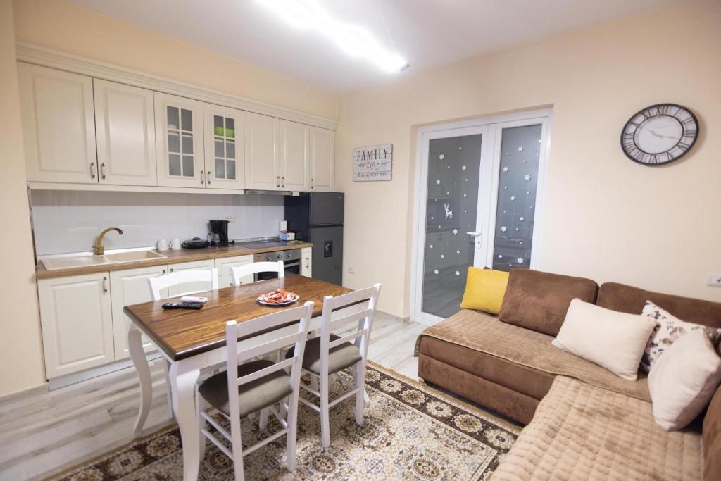 eine Küche und ein Wohnzimmer mit einem Tisch und einem Sofa in der Unterkunft Korca Luxury Apartments & Rooms in Korçë