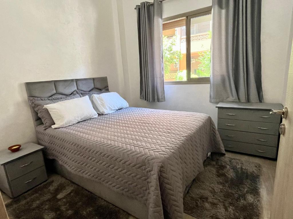 Habitación pequeña con cama y ventana en ASAMA appartement avec piscine en Marrakech