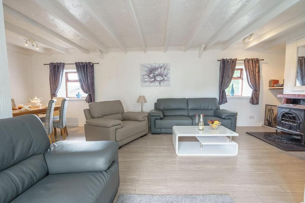 - un salon avec un canapé et une table dans l'établissement Templand Cottage, à Thornhill