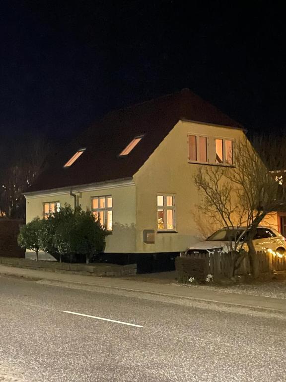 una casa al lado de una calle por la noche en Jelling en Jelling