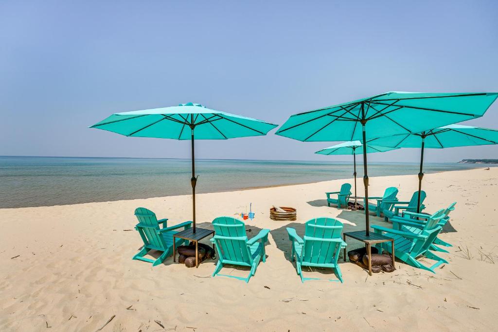 a group of chairs and umbrellas on a beach at Private Beachfront Lake Michigan Rental with Kayaks in Pentwater