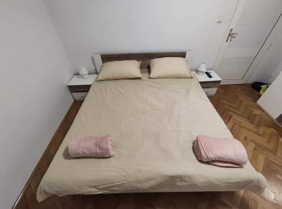 a large bed in a room with two pillows on it at Aretha apartman i sobe in Novi Vinodolski