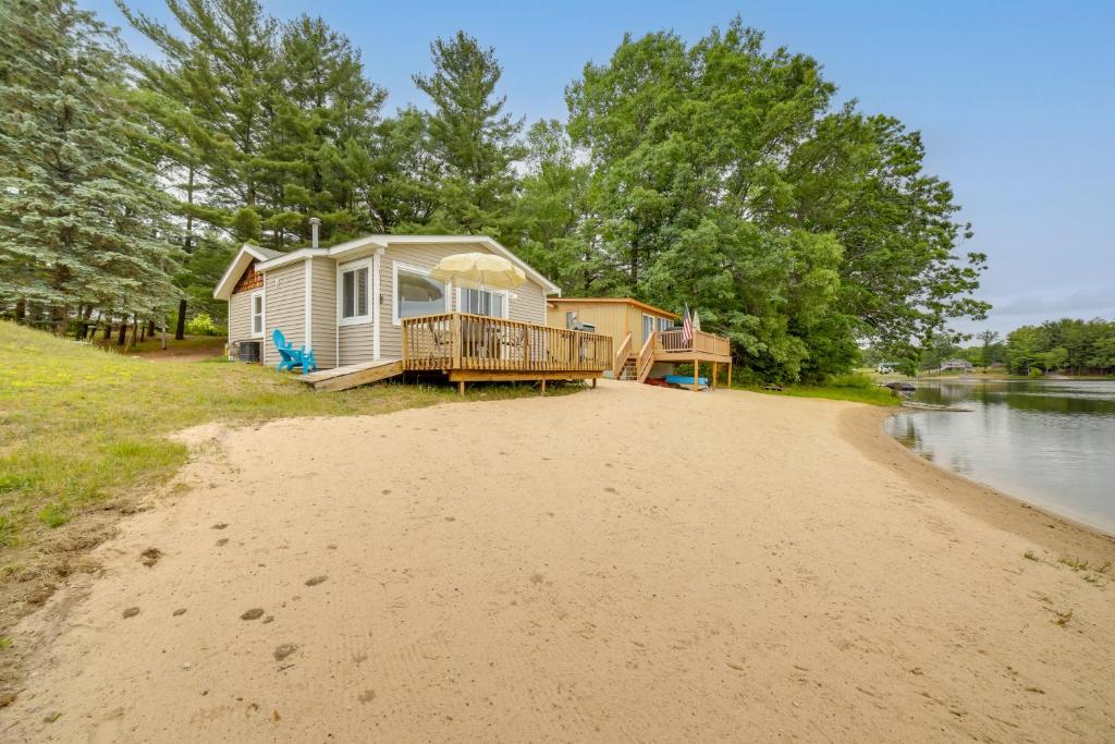 a house on a beach next to a river at Lake Vacation Rental with Deck and Gas Grill! in Lake