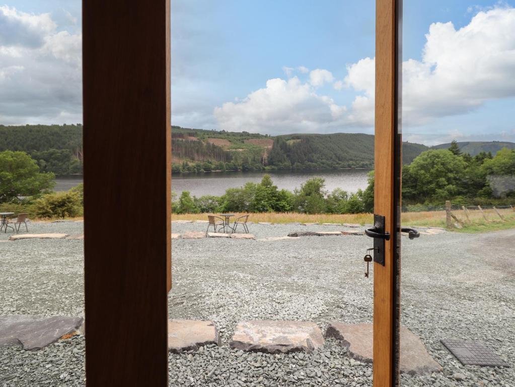 a door open to a view of a lake at Old Cart House in Oswestry