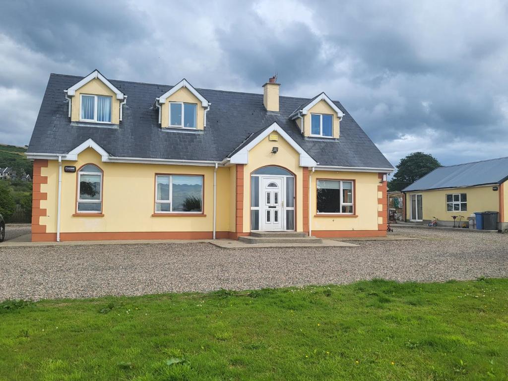 a large yellow house on a gravel driveway at Castleview in Milltown