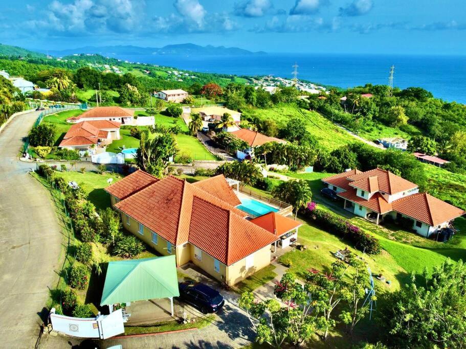una vista aérea de una casa en una colina junto al océano en VILLA PASKEDRA en Case-Pilote