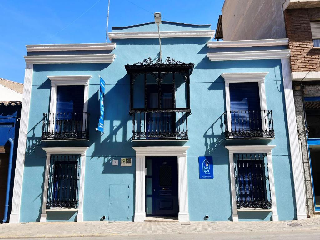 a blue building with balconies on a street at Hospedium Aloque Posada Hotel Rural in Valdepeñas