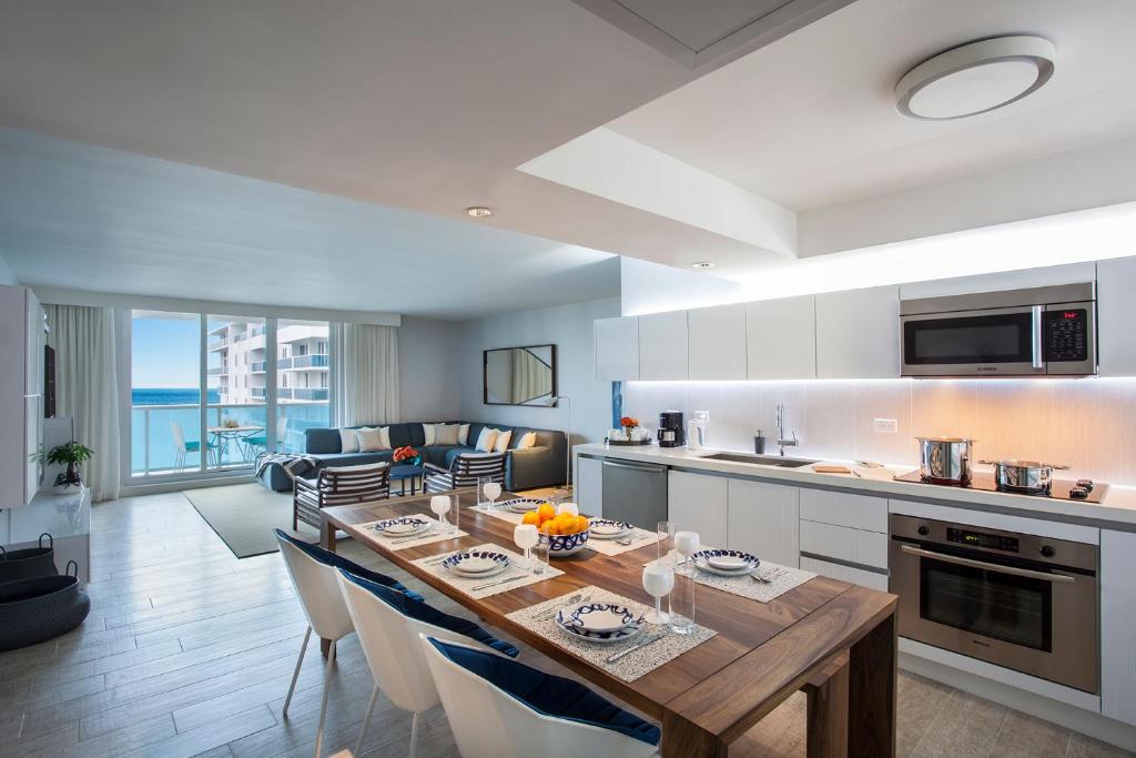 a kitchen and living room with a large wooden table at Incredible Ocean Views! Terrace, 1800 sq.ft., Hotel in Miami Beach