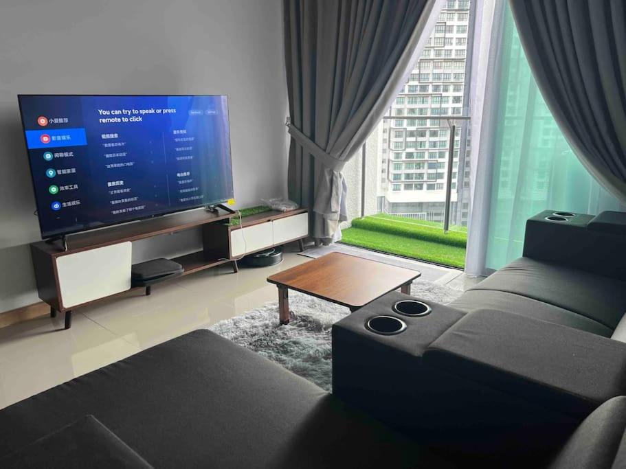 een woonkamer met een grote televisie en een bank bij Bliss Cool Home 2Rooms 4Pax 1CarPark 24H7D Easy Self Access in Kuala Lumpur