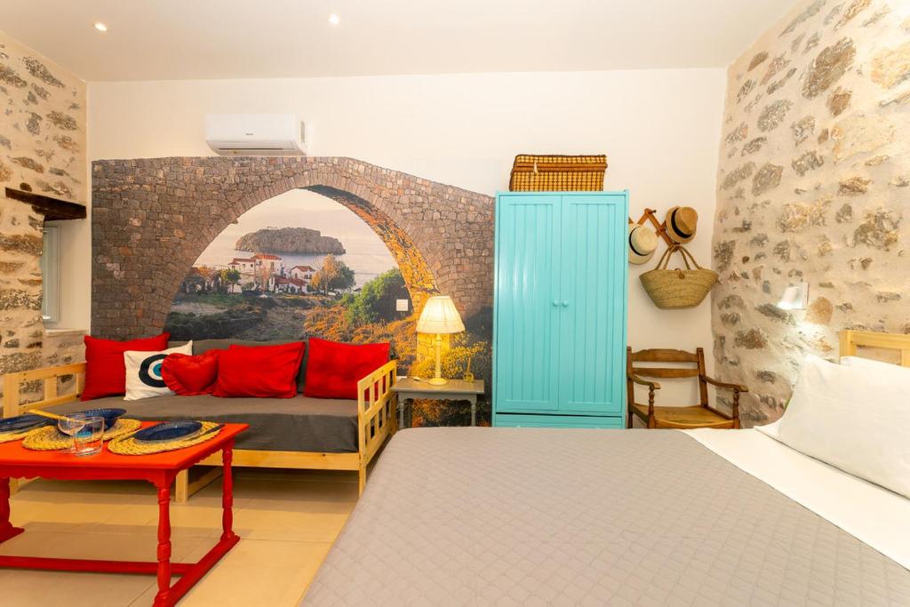 a bedroom with a bed and a couch and a table at Ydor apartment in Hydra