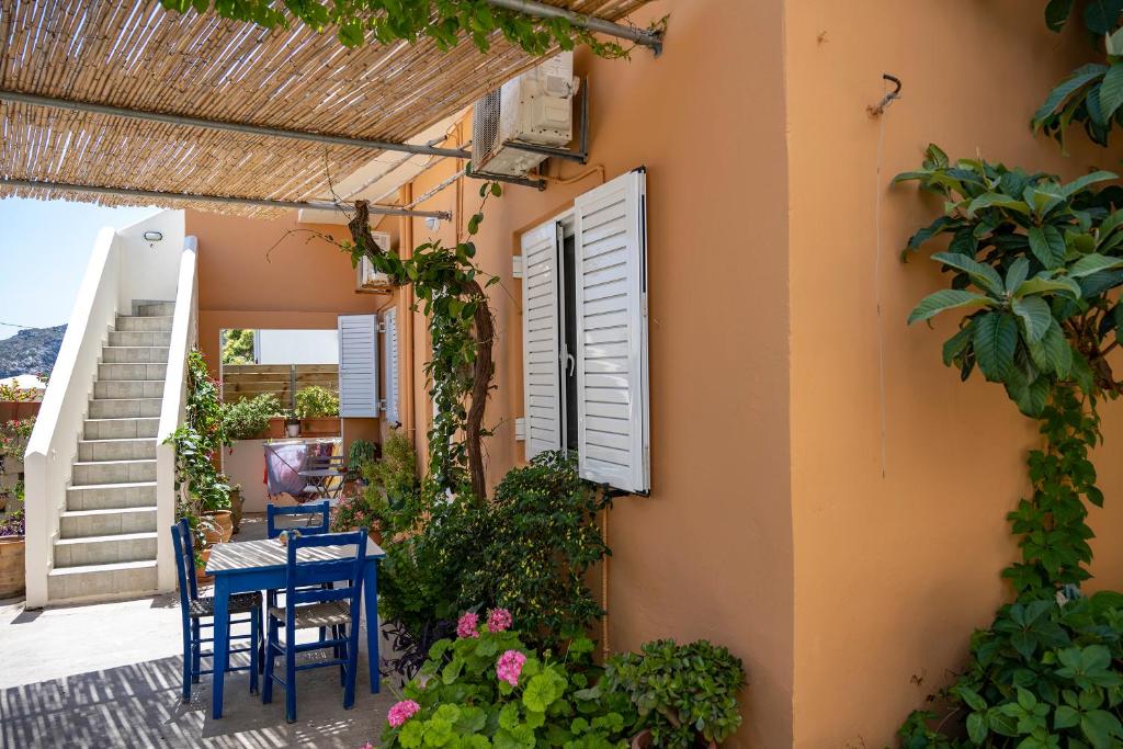 a patio with a table and chairs and plants at Katerina Rooms & Studios in Palekastron