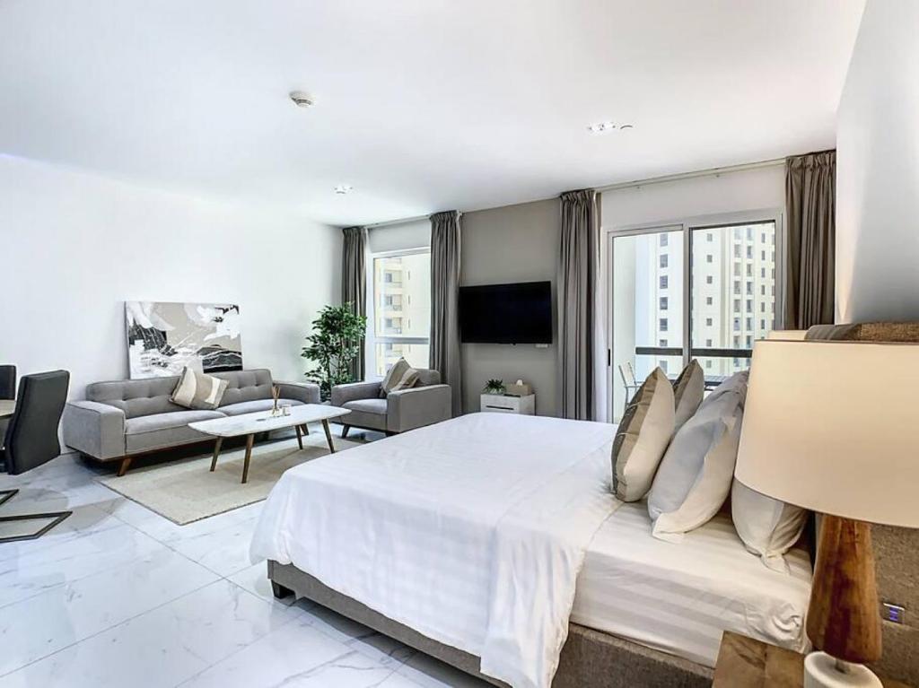 - une chambre blanche avec un grand lit et un salon dans l'établissement Key View - Murjan 2, JBR, à Dubaï