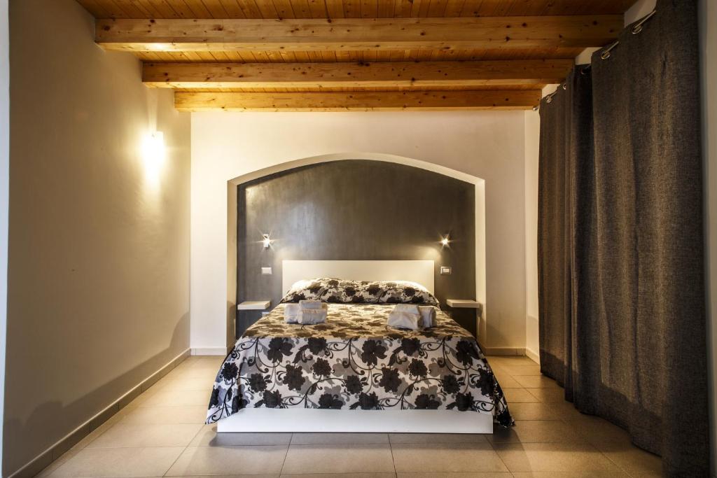 a bedroom with a bed with a large headboard at Opera Suite in Castellammare del Golfo