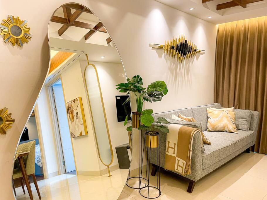 Una sala de estar con un sofá y un espejo. en The Jewel of La Casa, en Surabaya