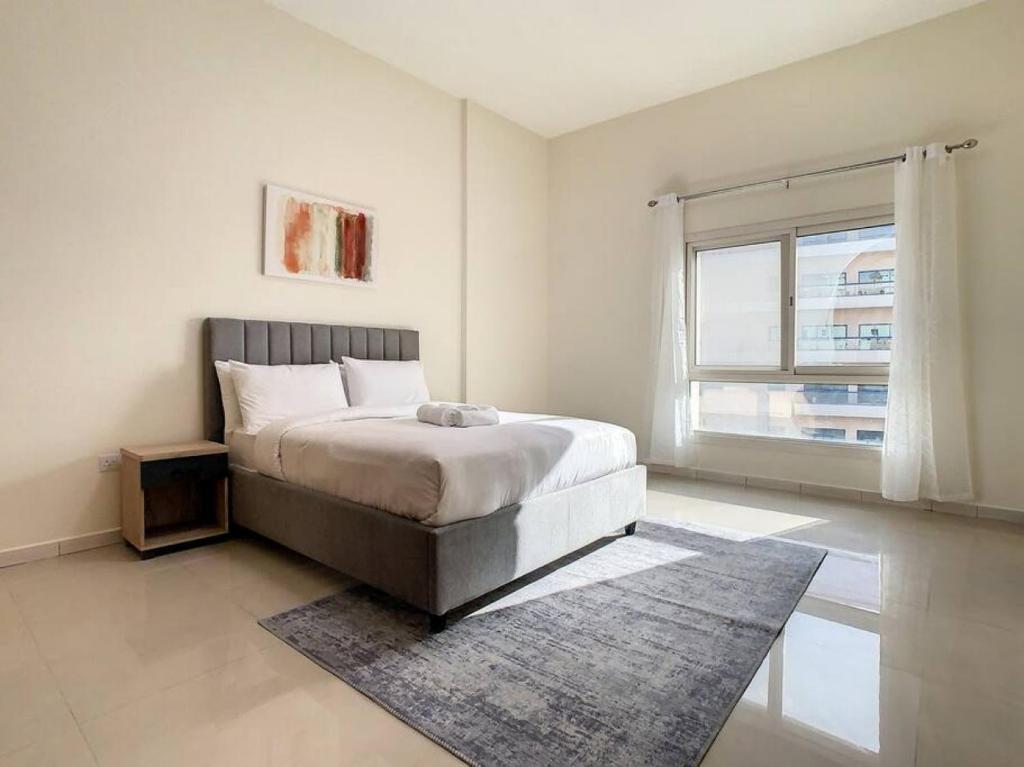a bedroom with a bed with a rug and a window at Key View - Silicon Star in Dubai