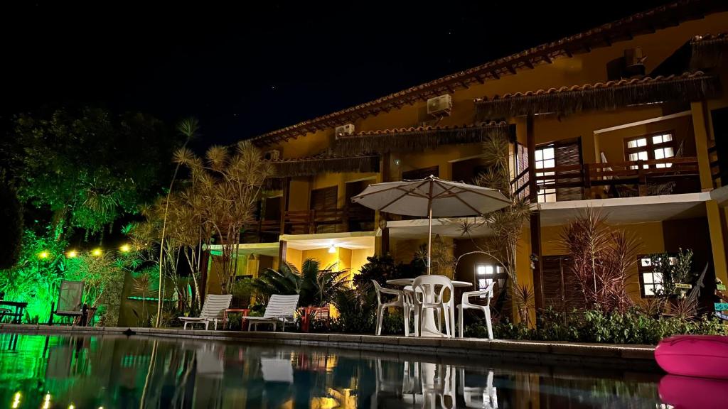 um hotel com piscina à noite em Pousada In Bali - Maresias em Maresias