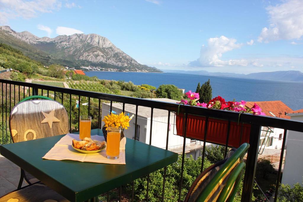 a table on a balcony with a view of the ocean at Guesthouse Podaca in Podaca