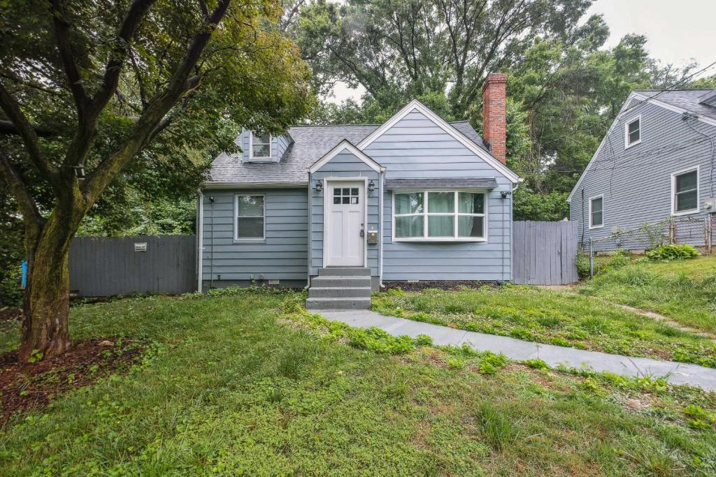 a blue house with a white door and a fence at Pet-Friendly Mount Rainier Home with Gas Grill! in Mount Rainier