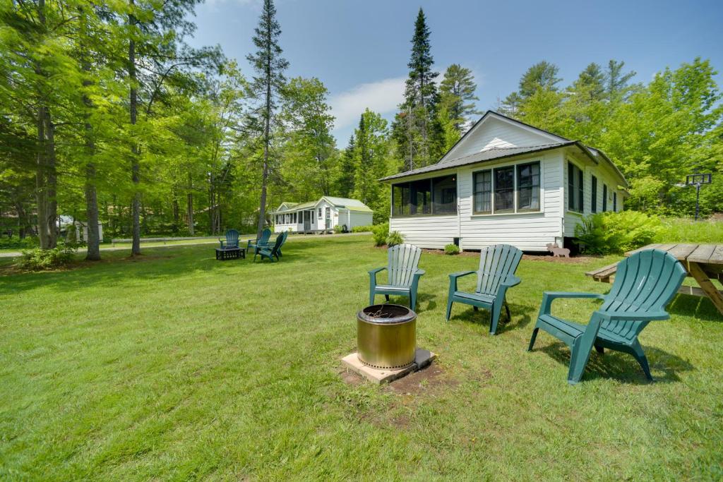 un gruppo di sedie seduti intorno al fuoco in un cortile di Lakefront Adirondack Getaway with Beach and Kayaks! a Lake Pleasant