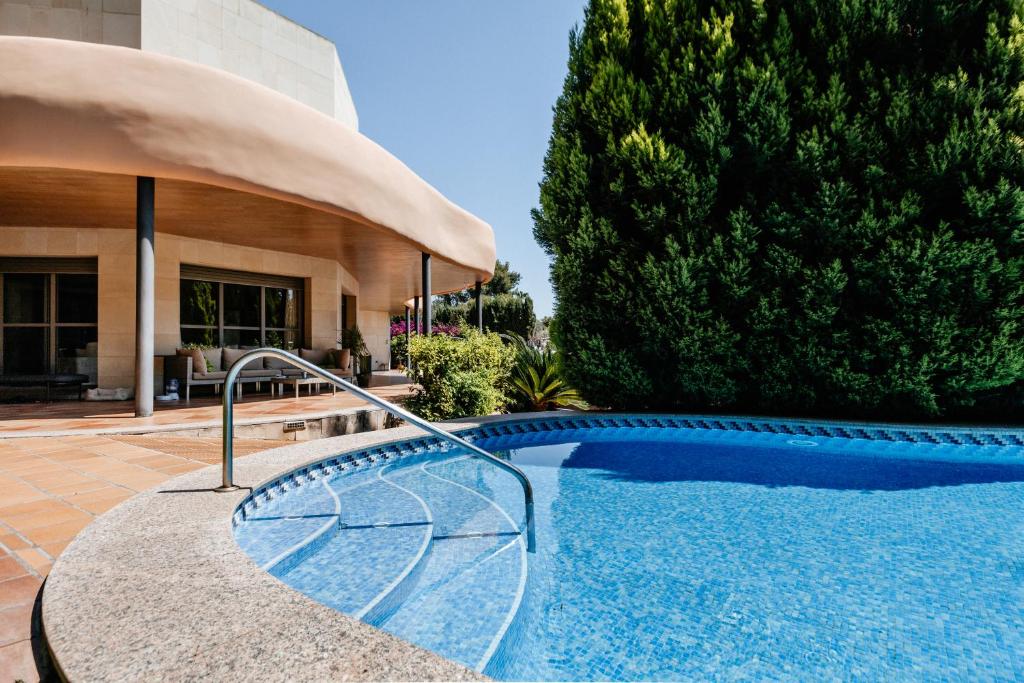 una piscina frente a una casa en Lushville - Luxurious Villa with Pool in Valencia, en Campo Olivar