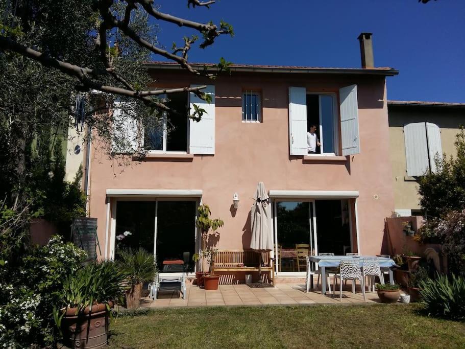 une maison avec un patio et une table devant dans l'établissement Hâvre de paix dans un écrin de verdure, à Avignon
