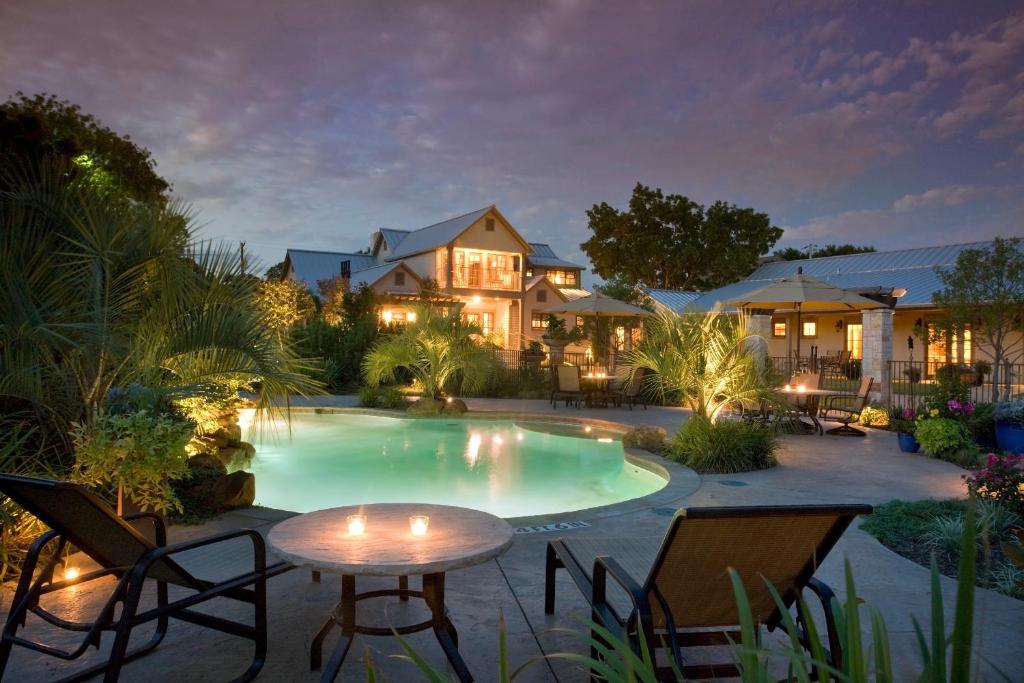 uma piscina com cadeiras e uma mesa em frente a uma casa em Inn on Lake Granbury em Granbury