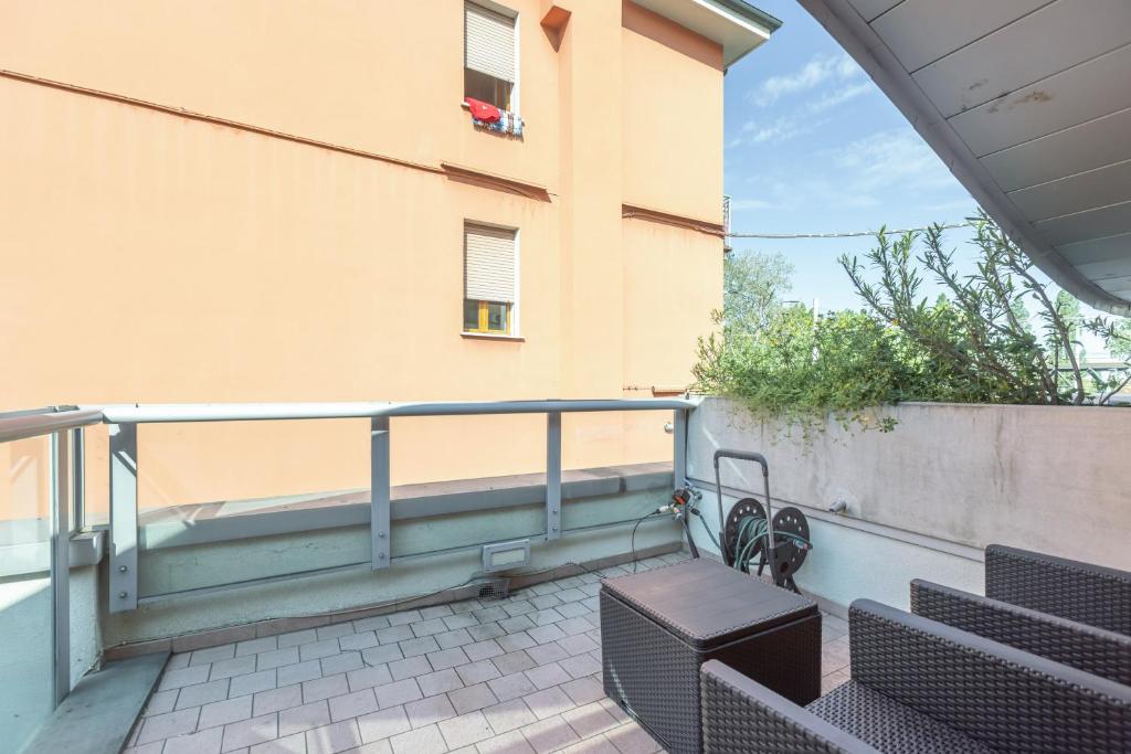 Chic & Modern apartment with terrace في بولونيا: شرفة مع مقعد ومبنى