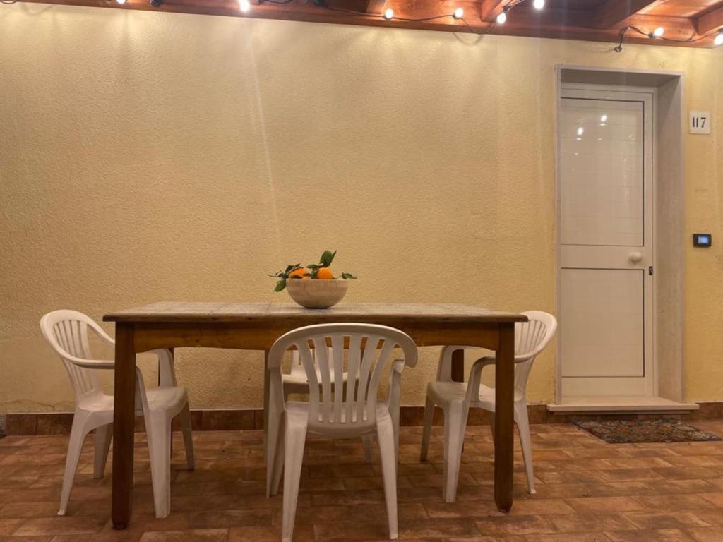 een tafel met stoelen en een fruitschaal erop bij La Casa di Maria in Ardore Marina