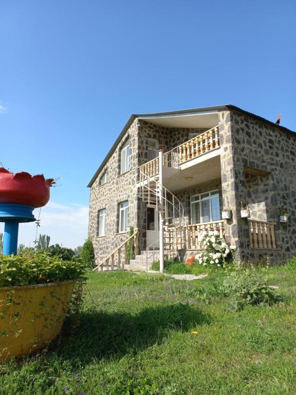 a stone house with scaffolding on the front of it at Guest House AREVIK in Artsvakar