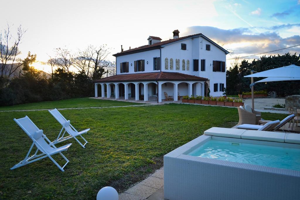 a house with two lawn chairs and a swimming pool at ColmarinoHouse 