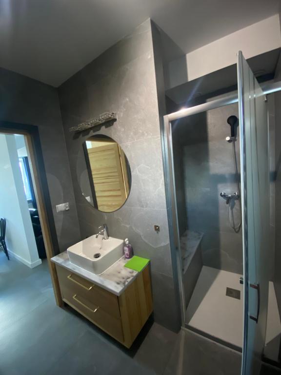 La salle de bains est pourvue d'un lavabo et d'une douche. dans l'établissement Na Pensjonatowej, à Augustów