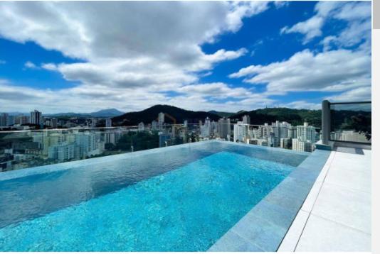 uma piscina no topo de um edifício com uma cidade em Ap próximo a Vila Germânica Acomoda até 4 pessoas em Blumenau