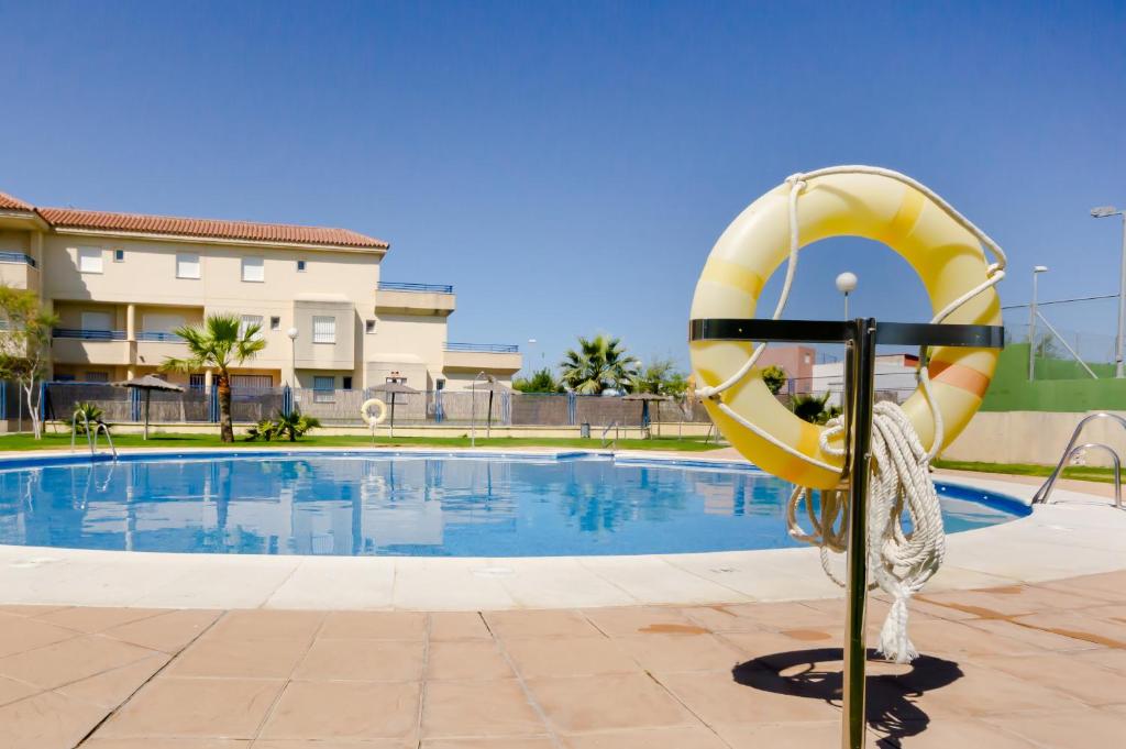 a swimming pool with a yellow lifesaver at Apartamentos Sanlúcar &amp; Doñana in Sanlúcar de Barrameda