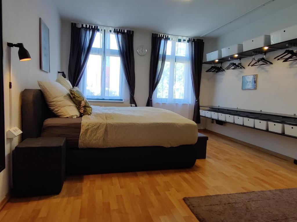 1 dormitorio con 1 cama grande y 2 ventanas en Wohlfühl-Wohnung im Herzen der Stadt Magdeburg, en Magdeburgo
