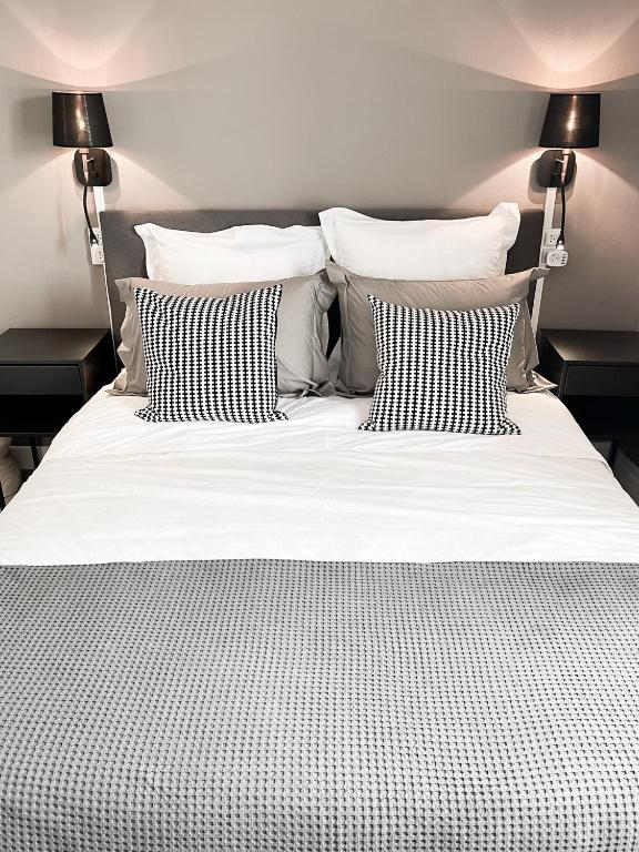 - un lit avec des oreillers en noir et blanc dans l'établissement Studio Loubes Bernac, à Loubès-Bernac