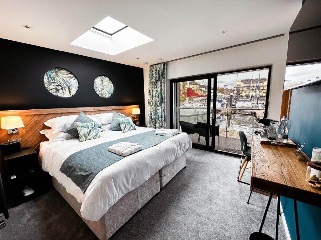 a bedroom with a large bed and a desk and window at Rooms at The Deck, Penarth in Cardiff