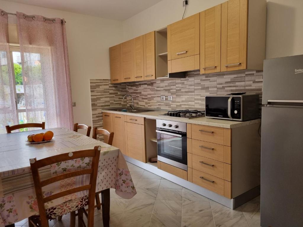 una cucina con armadi in legno e un tavolo con forno a microonde di casa didi' a Città di Lipari