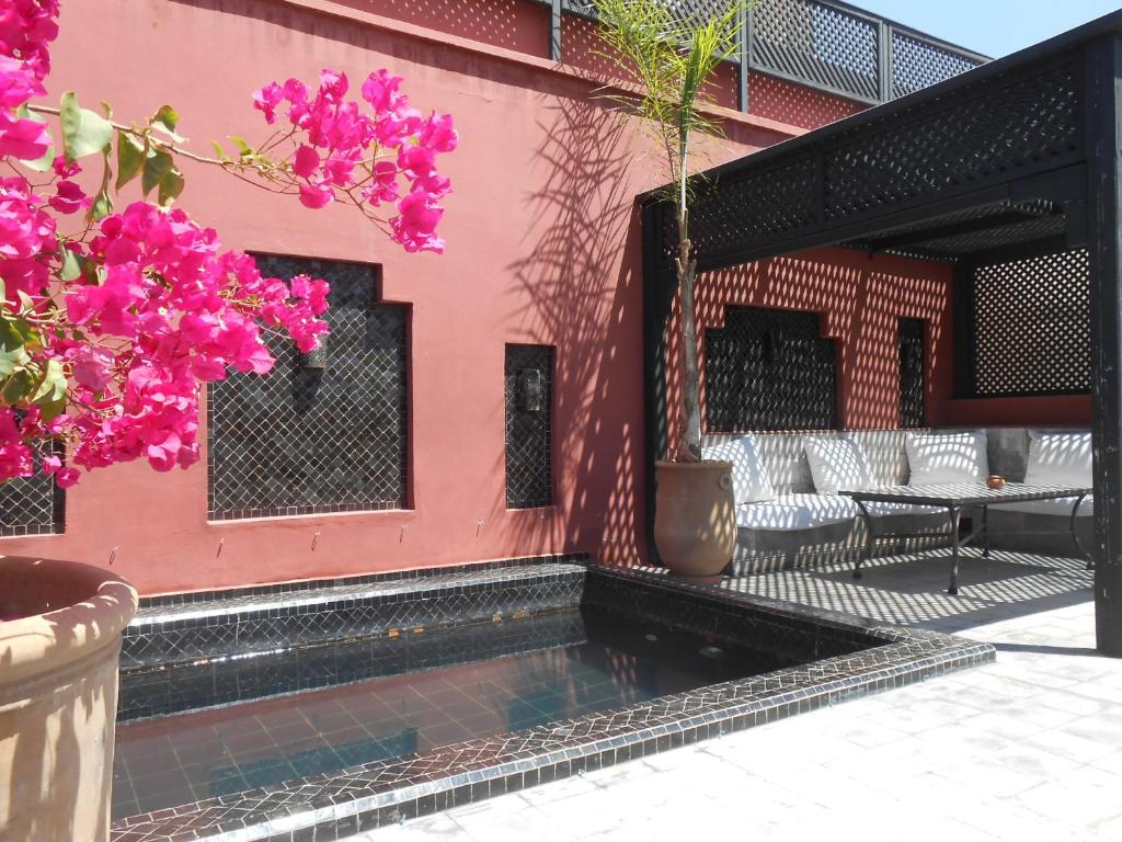 a pink building with a patio with pink flowers at Riad Alegria in Marrakesh