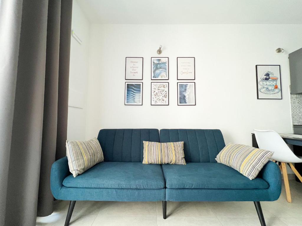 a blue couch sitting in a living room with curtains at Sunnyside Apartment in Torre Grande