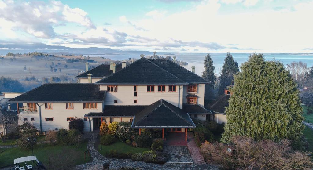 eine Luftansicht eines Hauses mit einem Baum in der Unterkunft Hotel y Cabañas Lago Ranco - Caja los Andes in Futrono