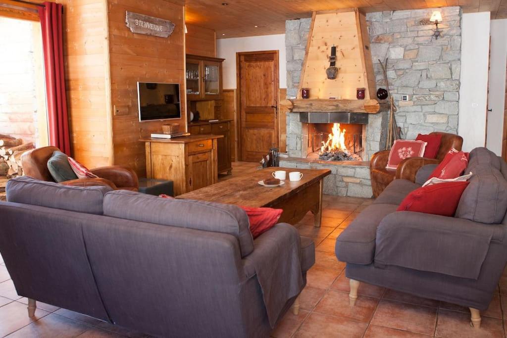 un salon avec deux canapés et une cheminée dans l'établissement Les 4 saisons - luxury 3-bed apt with sauna, à Sainte-Foy-Tarentaise