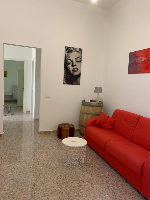 un soggiorno con un divano rosso e un tavolo di CONTINOWINES a Lequile