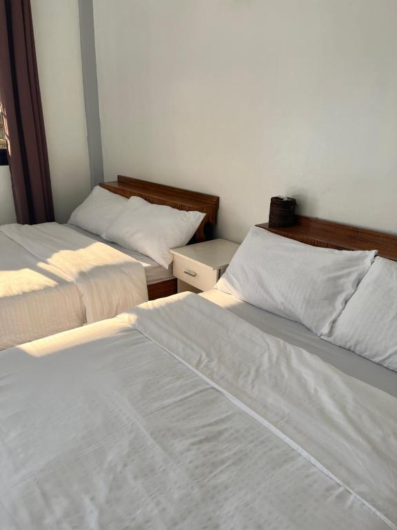Santa Ana的住宿－Montana Place Camp & Accommodations，一间卧室配有两张带白色床单的床