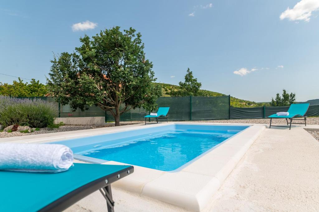 einen Pool mit 2 Stühlen und einem Tisch in der Unterkunft Villa Dalmatina 