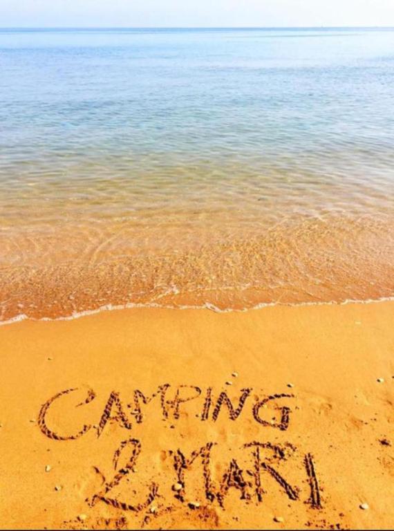 a sign written in the sand on the beach at Campeggio 2 Mari in Ovile la Marinella