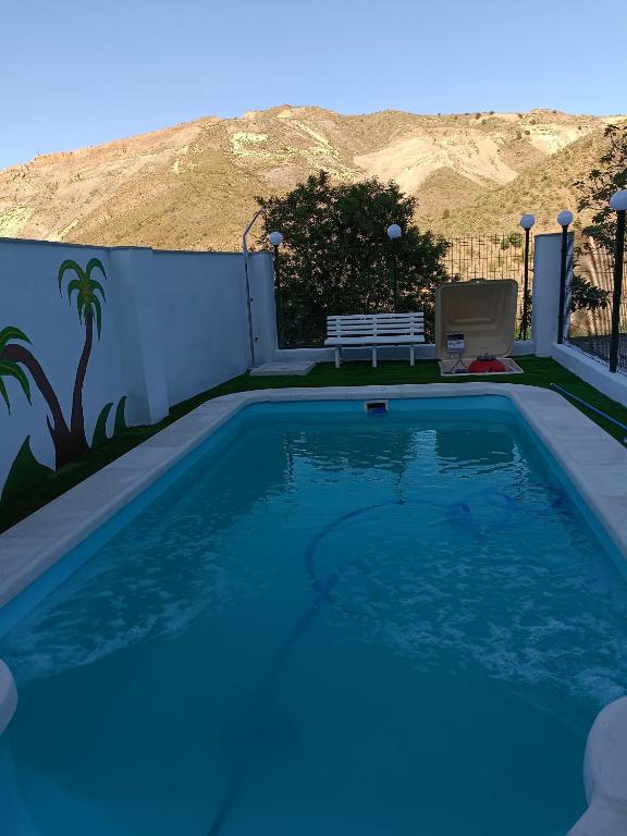 - une piscine avec un banc à côté d'une clôture dans l'établissement Casa rural Mccoy, à Macael
