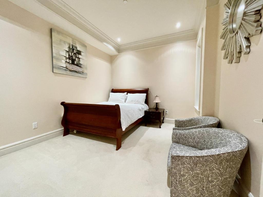 een slaapkamer met een bed en een stoel bij Vancouver Luxury Guest House in Vancouver