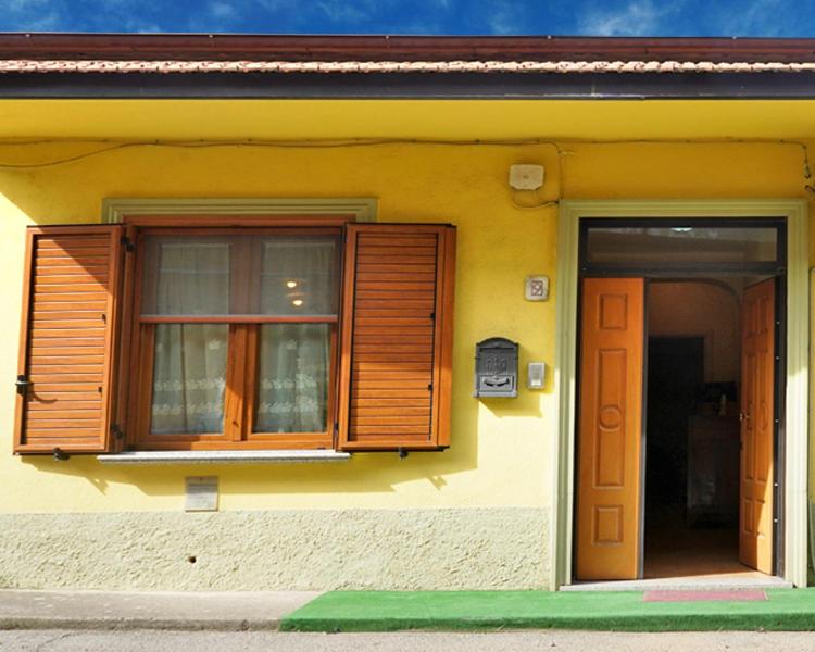 a house with wooden windows and a door at LE MIMOSE in Spezzano Albanese