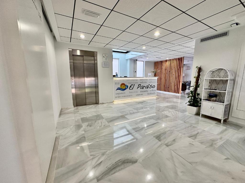 een lobby met een marmeren vloer en een lift bij Hotel El Paraíso in Calabardina